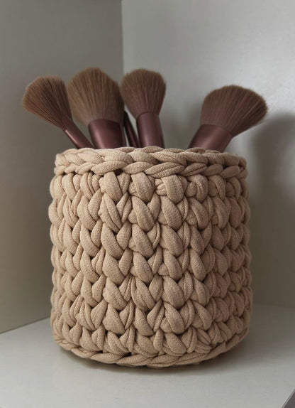 Beige gehaakt mandje met make-up brushes in